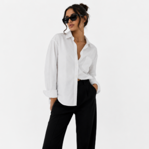 Femme portant une chemise blanche oversize avec un pantalon noir.